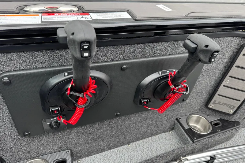 Slide: The Image of Control panel of 2026 Lund 1975 Pro-V Sport boat with dual throttle levers. - 18