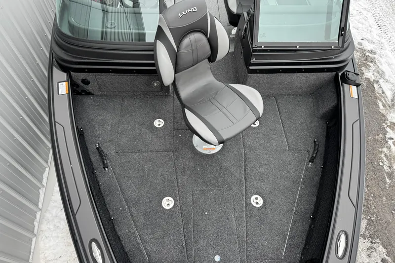 Slide: The Image of 2026 Lund 1975 Pro-V Sport boat interior with gray seating and carpeted deck. - 19