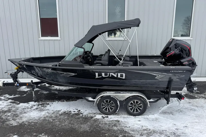 Slide: The Image of 2026 Lund 1975 Pro-V Sport boat on trailer, parked on snowy ground. - 3