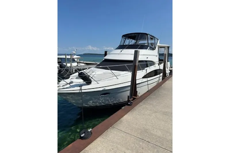 The Image of 2004 Carver 396 Motor Yacht docked at marina under clear blue sky. - 0