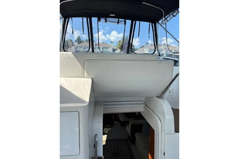 Slide: The Image of 2004 Carver 396 Motor Yacht interior with covered seating and open cabin entrance. - 10