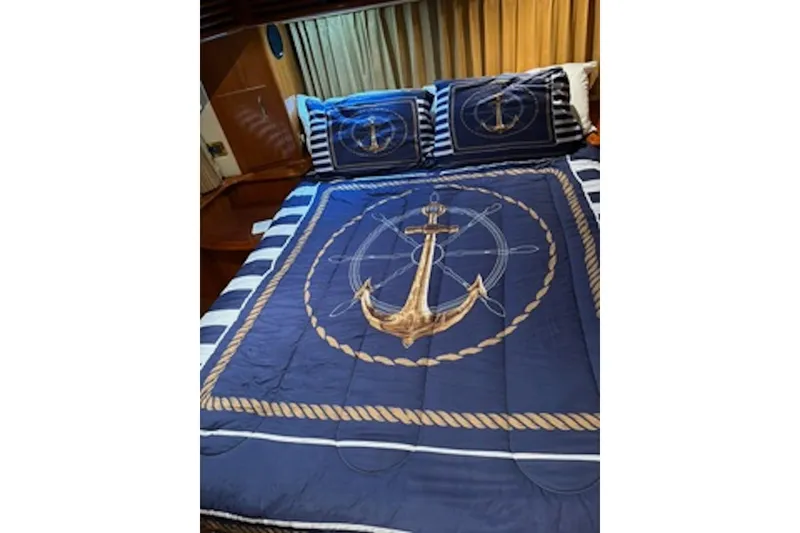 Slide: The Image of Nautical-themed bedding with anchor design in a 2004 Carver 396 Motor Yacht cabin. - 11