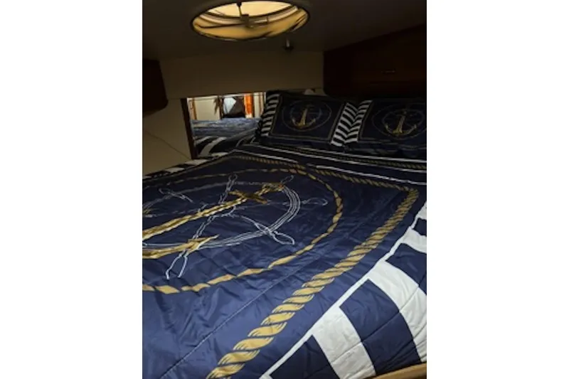 Slide: The Image of Nautical-themed bedroom in 2004 Carver 396 Motor Yacht with anchor-patterned bedding. - 12