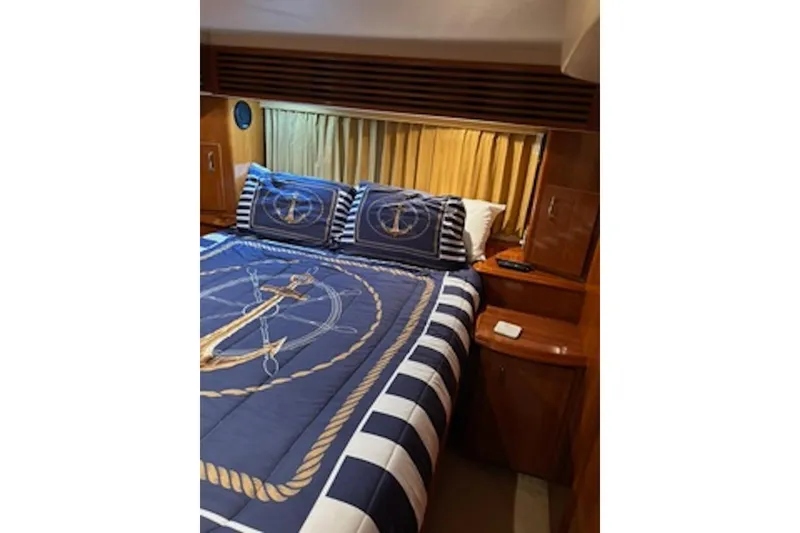 Slide: The Image of Luxurious bedroom interior of 2004 Carver 396 Motor Yacht with nautical-themed bedding. - 14
