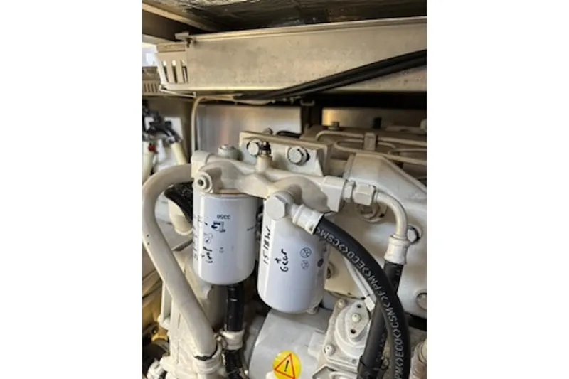 Slide: The Image of Engine components of a 2004 Carver 396 Motor Yacht, featuring filters and hoses. - 24