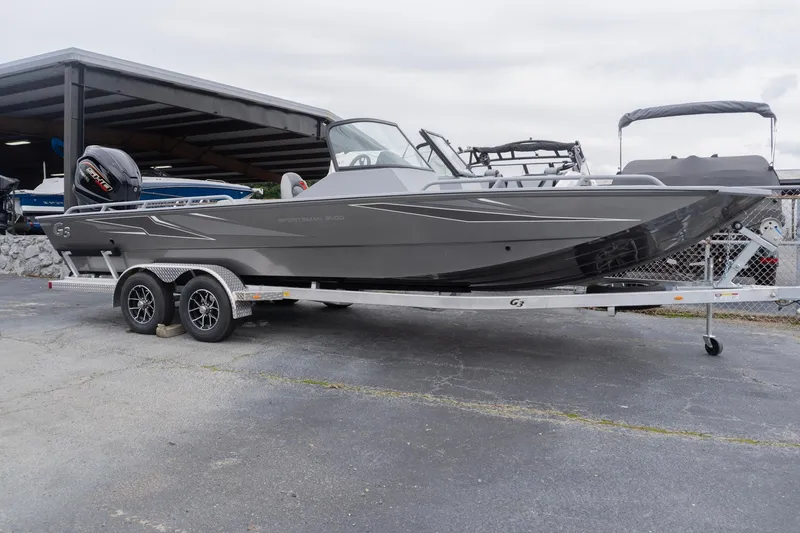 The Image of 2026 G3 Sportsman 2400 boat on trailer, sleek gray design, parked outdoors. - 0