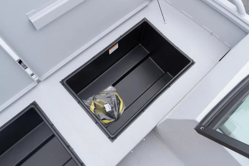 Slide: The Image of Open storage compartment on 2026 G3 Sportsman 2400 boat with life jacket inside. - 12