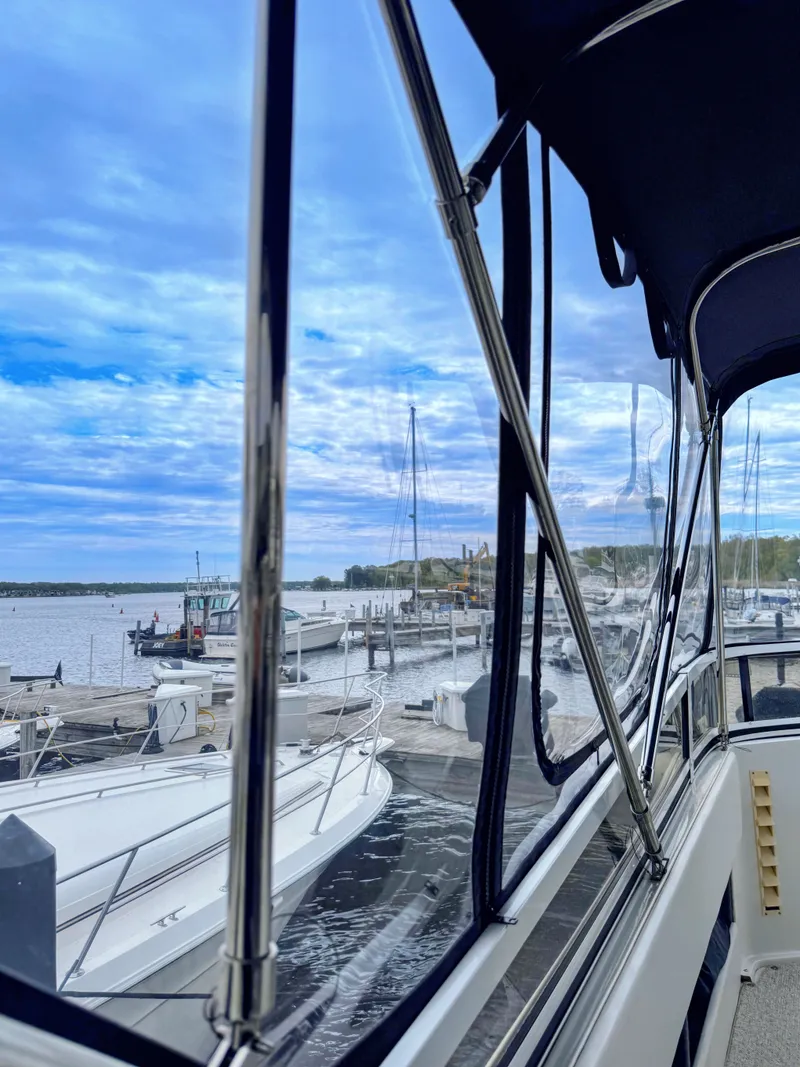 Slide: The Image of 1999 Carver 406 Aft Cabin Yacht docked under blue sky. - 11
