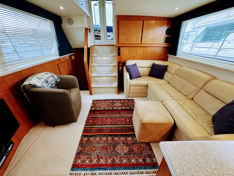 Slide: The Image of Interior of Carver 406 Aft Cabin Yacht, cozy living area with sofa and rug. - 33