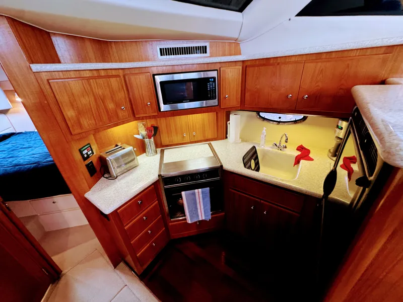 Slide: The Image of Interior of Carver 406 Aft Cabin Yacht, kitchen with wooden cabinets, 1999 model. - 34