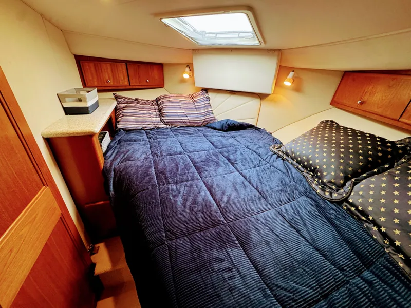 Slide: The Image of Interior of Carver 406 Aft Cabin Yacht, cozy bedroom with blue bedding. - 38
