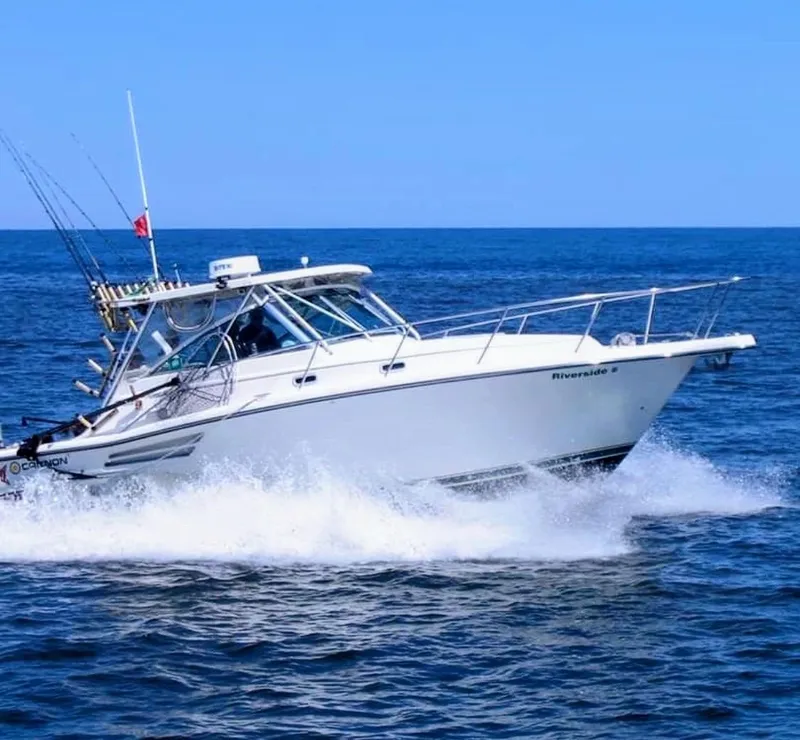 The Image of 1999 Pursuit 3400 Express boat cruising on open sea. - 0