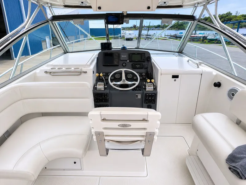 Slide: The Image of Interior of a 1999 Pursuit 3400 Express yacht, featuring helm and seating area. - 11