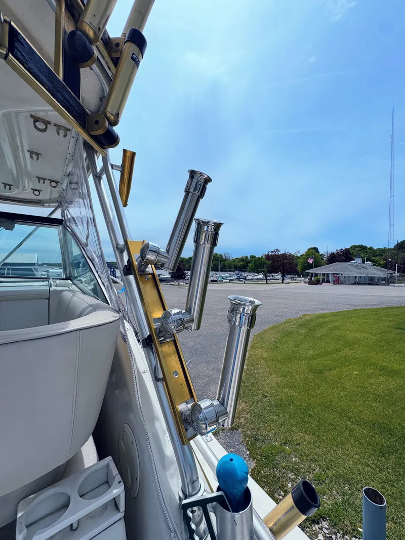 Slide: The Image of 1999 Pursuit 3400 Express boat with fishing rod holders at the marina. - 15