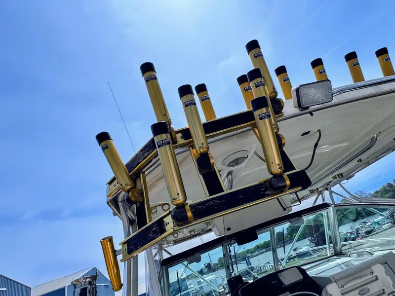 Slide: The Image of 1999 Pursuit 3400 Express with fishing rod holders under blue sky. - 17