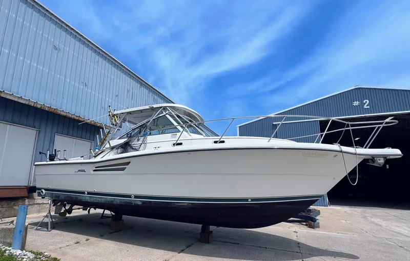 Slide: The Image of 1999 Pursuit 3400 Express boat outside warehouse. - 2