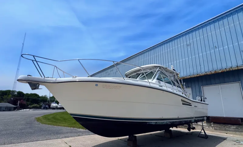 Slide: The Image of 1999 Pursuit 3400 Express boat in front of warehouse. - 3