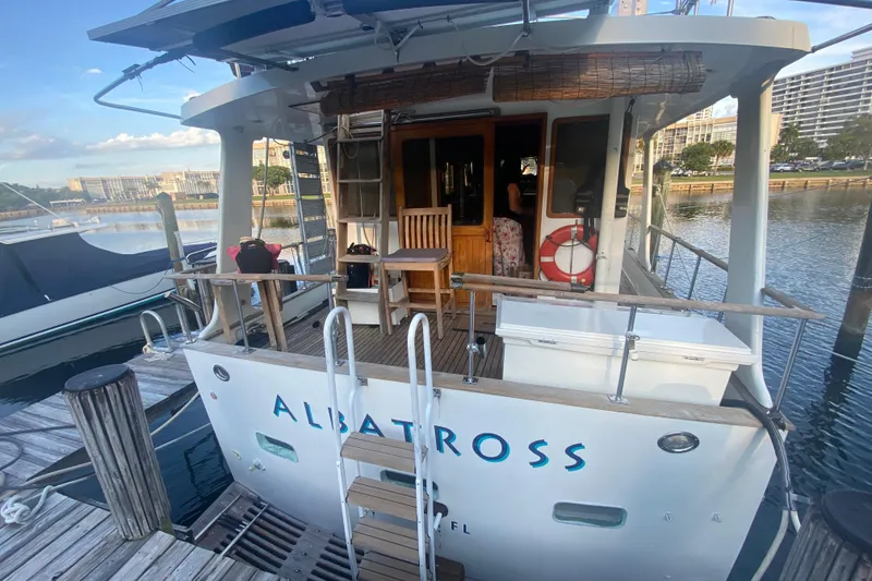 Slide: The Image of 1985 Marine Trader 50 Motor Yacht "Albatross" docked at marina with wooden deck and life preserver. - 2