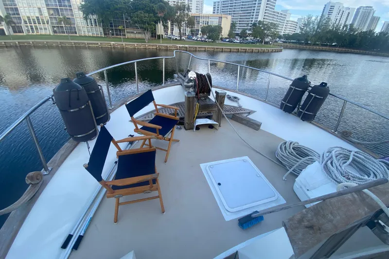 Slide: The Image of 1985 Marine Trader 50 Motor Yacht deck with chairs, ropes, and waterfront view. - 3