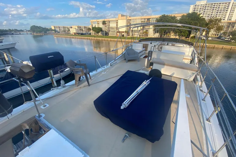 Slide: The Image of 1985 Marine Trader 50 Motor Yacht deck with seating, docked by waterfront buildings. - 5