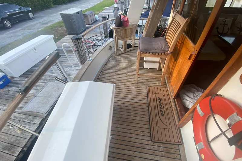 Slide: The Image of 1985 Marine Trader 50 Motor Yacht deck with wooden flooring and seating area. - 8