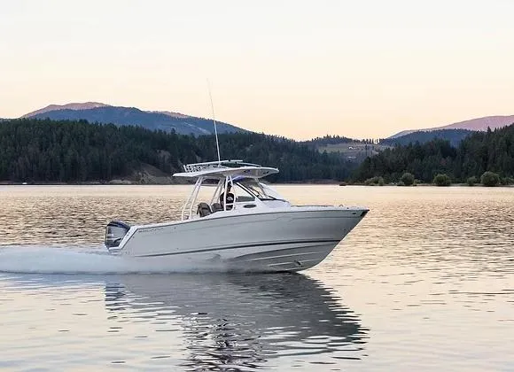 Slide: The Image of 2025 Solara 250 Center Walkaround boat cruising on a serene lake at sunset. - 2