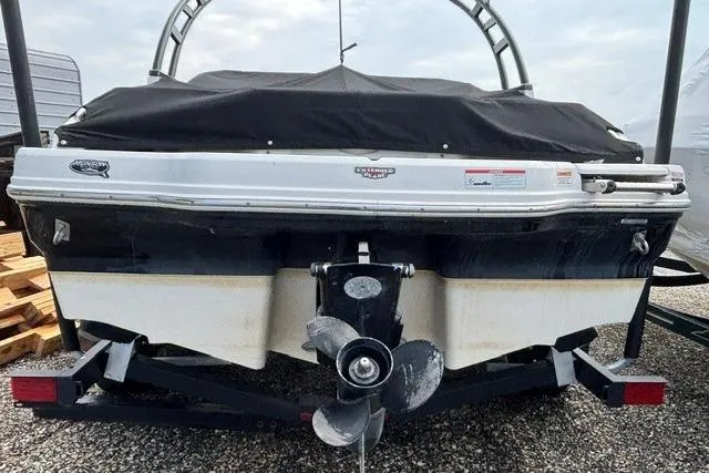 Slide: The Image of Rear view of a 2021 Chaparral 21 SSi boat with a covered top and visible propeller. - 11