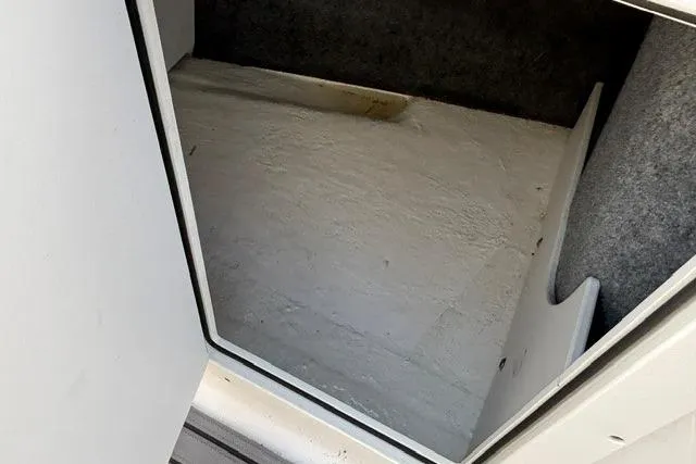 Slide: The Image of Storage compartment in a 2021 Chaparral 21 SSi boat, featuring a clean interior. - 17