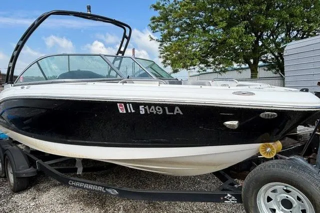 Slide: The Image of 2021 Chaparral 21 SSi boat on trailer, black and white exterior, parked outdoors. - 30