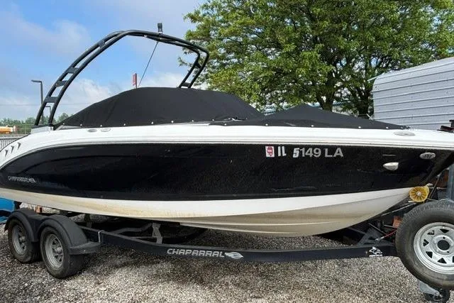 Slide: The Image of 2021 Chaparral 21 SSi boat on trailer, black hull, covered, parked outdoors. - 31