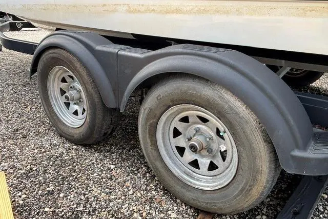 Slide: The Image of Trailer wheels of a 2021 Chaparral 21 SSi boat on gravel surface. - 38