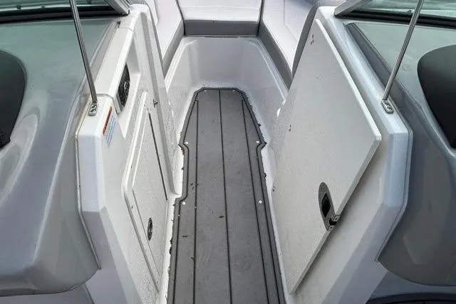 Slide: The Image of 2021 Chaparral 21 SSi boat interior, featuring sleek gray flooring and white paneling. - 8