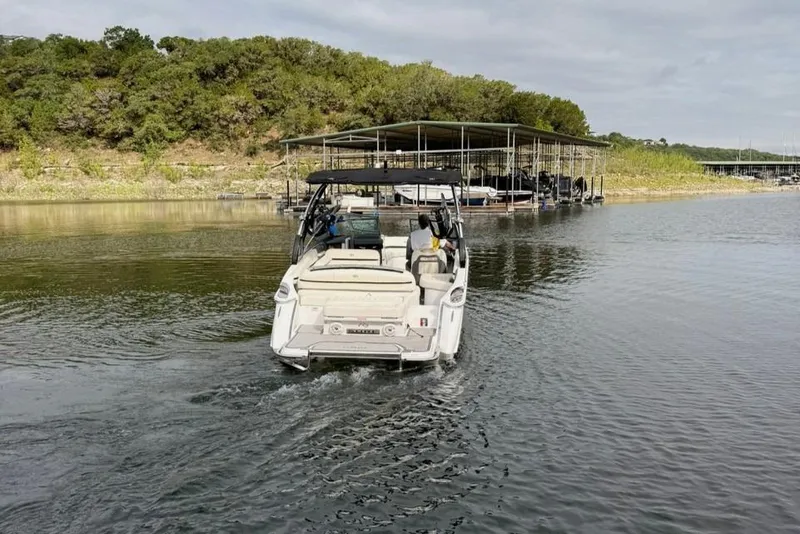Slide: The Image of 2018 Cobalt R5 WSS Surf boat navigating near a dock on a calm lake. - 10