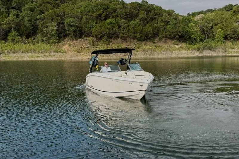 Slide: The Image of 2018 Cobalt R5 WSS Surf boat cruising on a serene lake with lush green shoreline. - 17
