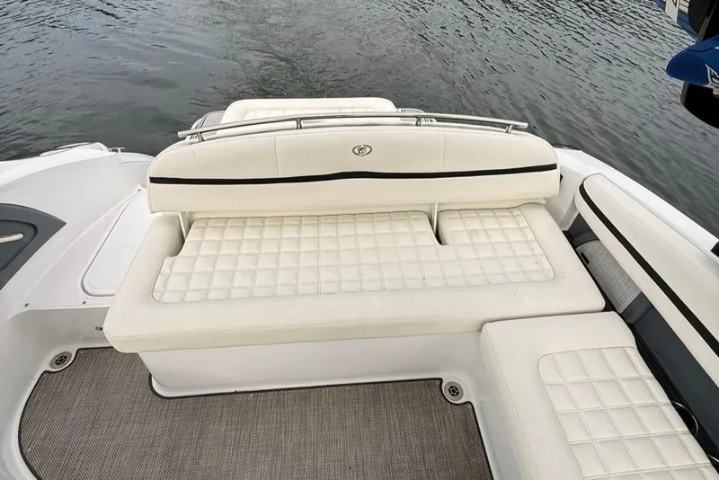 Slide: The Image of 2018 Cobalt R5 WSS Surf boat with white cushioned seating by the water. - 23