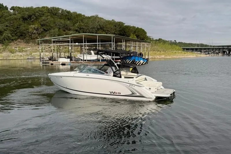 Slide: The Image of 2018 Cobalt R5 WSS Surf boat on calm lake near docks and greenery. - 8