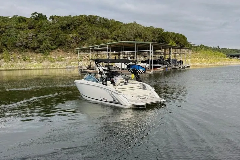 Slide: The Image of 2018 Cobalt R5 WSS Surf boat cruising near a dock on a calm lake. - 9