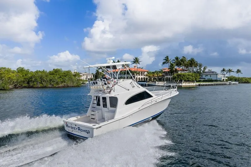 Slide: The Image of 2005 Luhrs 38 Convertible yacht cruising near waterfront homes. - 17