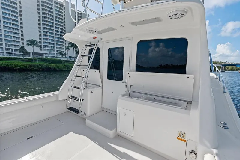 Slide: The Image of 2005 Luhrs 38 Convertible yacht deck with ladder, docked near waterfront buildings. - 21
