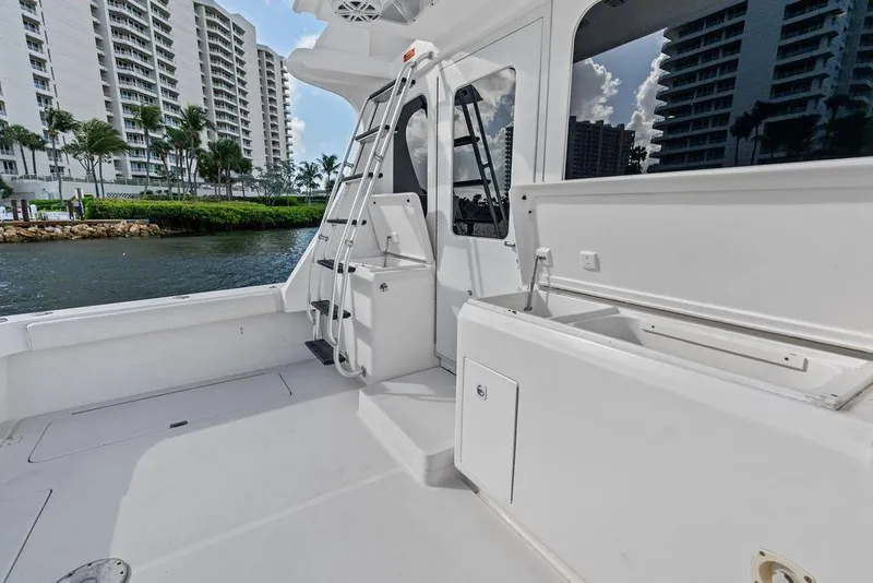 Slide: The Image of 2005 Luhrs 38 Convertible yacht deck with ladder, near waterfront buildings. - 22