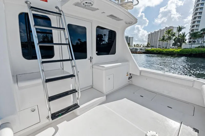 Slide: The Image of 2005 Luhrs 38 Convertible yacht deck with ladder, overlooking waterfront and cityscape. - 25