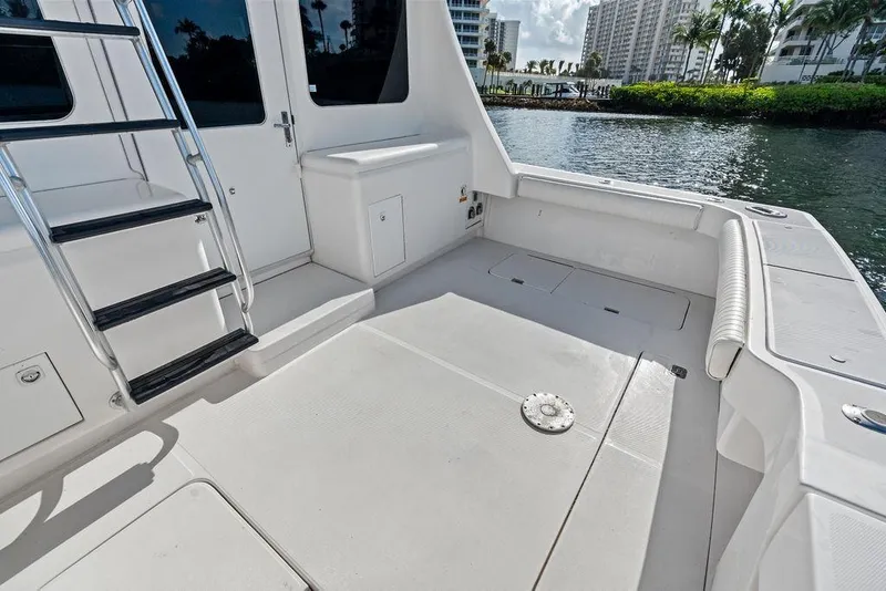 Slide: The Image of 2005 Luhrs 38 Convertible boat deck with ladder, docked by waterfront buildings. - 26
