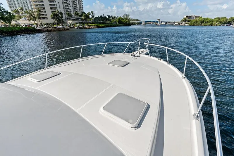 Slide: The Image of 2005 Luhrs 38 Convertible yacht cruising on a scenic waterway near urban skyline. - 32