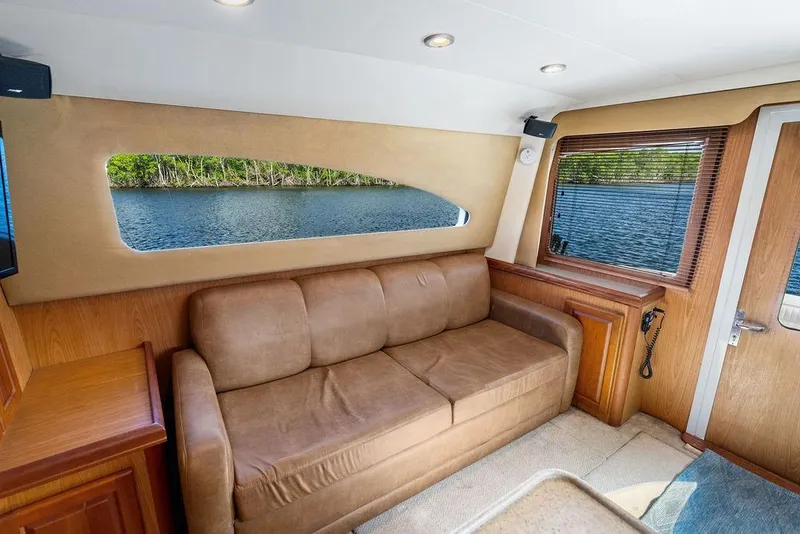 Slide: The Image of Interior of 2005 Luhrs 38 Convertible yacht with brown sofa and scenic water view. - 35