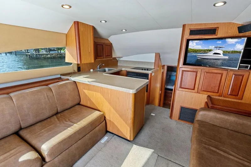 Slide: The Image of Interior of 2005 Luhrs 38 Convertible yacht with kitchen, seating, and TV. - 38