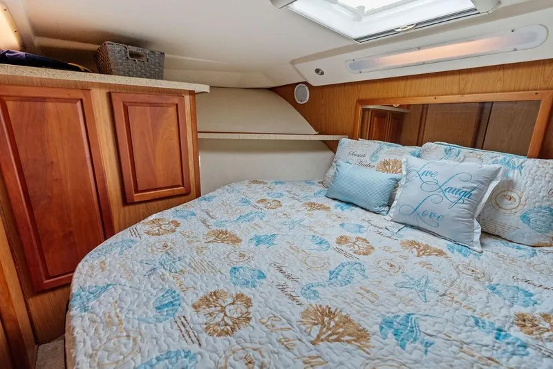 Slide: The Image of Cozy cabin interior of 2005 Luhrs 38 Convertible with nautical-themed bedding. - 53