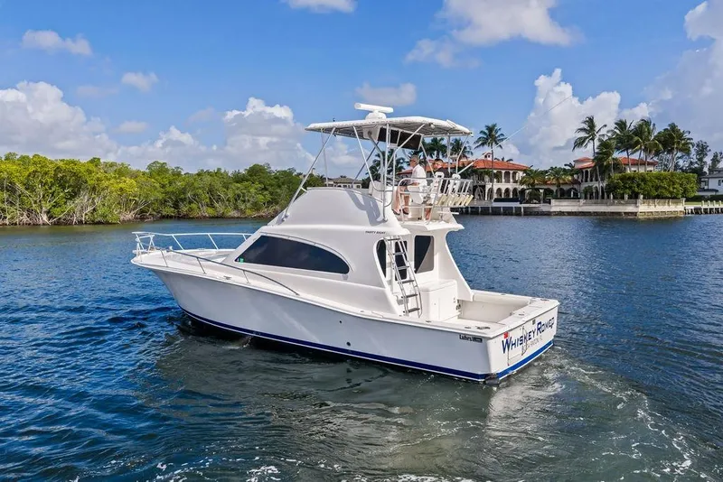Slide: The Image of 2005 Luhrs 38 Convertible yacht cruising on a sunny day near waterfront homes. - 7