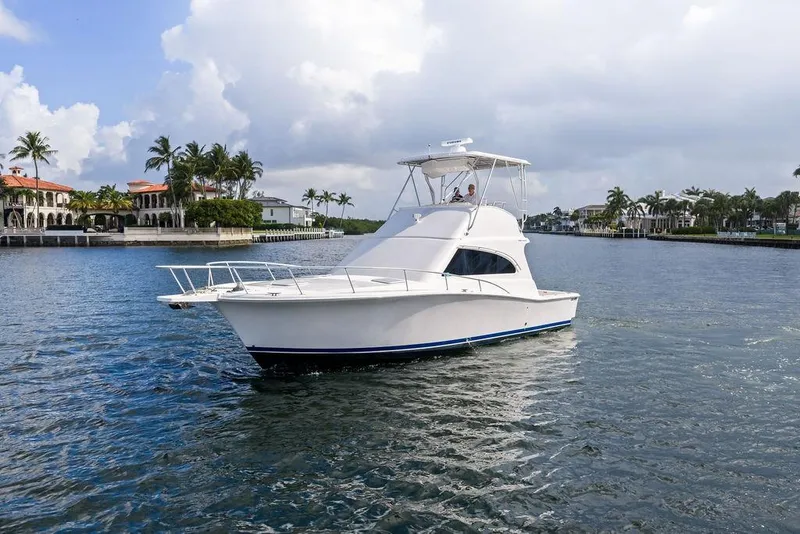 Slide: The Image of 2005 Luhrs 38 Convertible yacht cruising near waterfront homes and palm trees. - 8