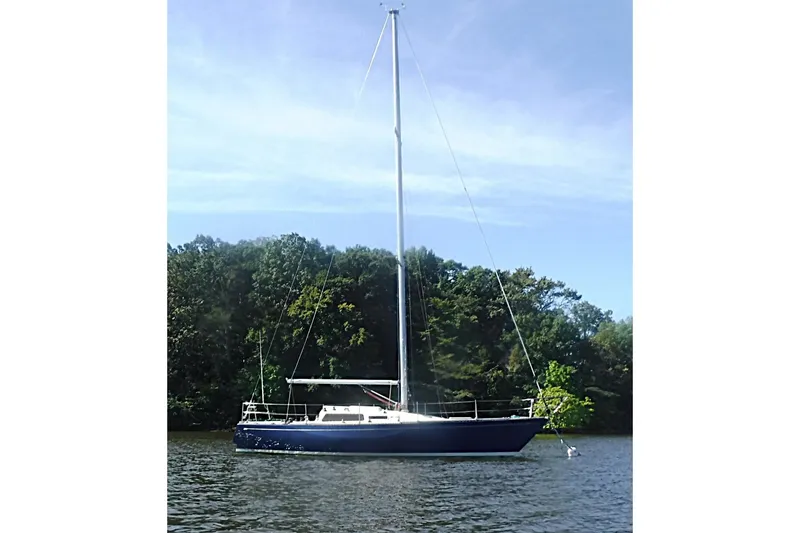 Slide: The Image of 1975 Carter 3/4 Ton sailboat on calm water with forested background. - 4