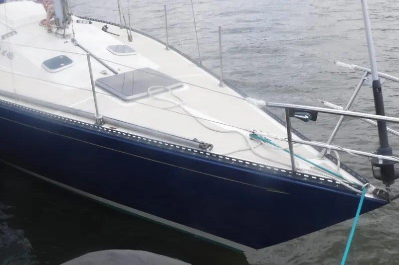 Slide: The Image of 1975 Carter 3/4 Ton sailboat with blue hull docked on calm water. - 11